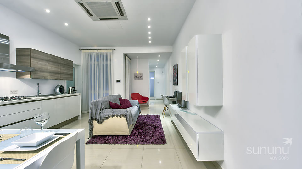 Sleek white themed living room of apartment in Sliema